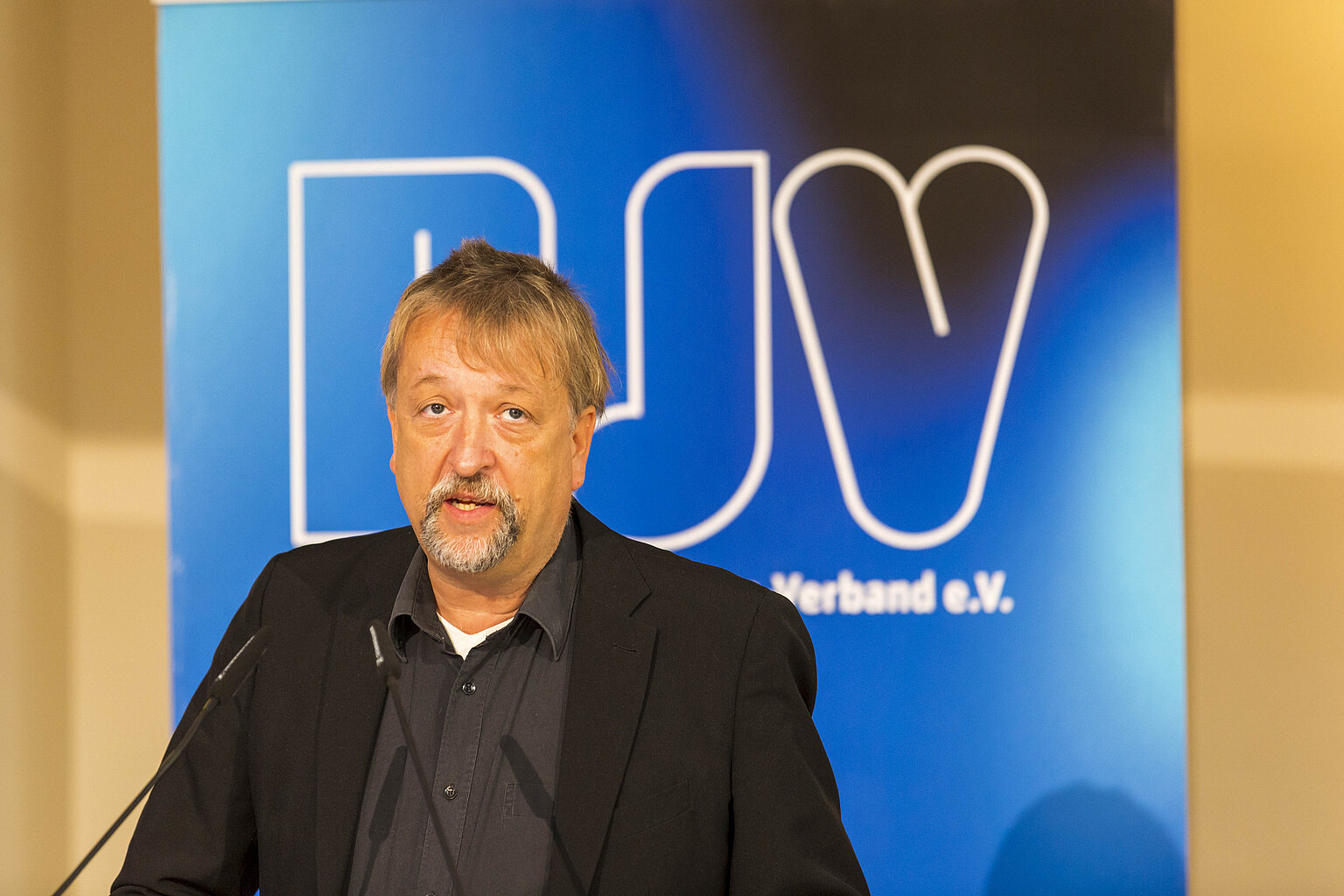 Michael Busch am Rednerpult bei der BJV-Mitgliederversammlung 2021 in München Alt: Michael Busch am Rednerpult bei der BJV-Mitgliederversammlung 2021 in München – Michael Busch wurde in München von den BJV-Mitgliedern für eine fünfte Wahlzeit gewählt