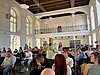 Ein Teilnehmer spricht auf der Konferenz, er steht inmitten des Publikums – 