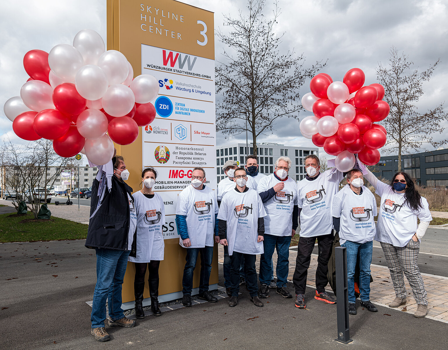 Zehn Journalist*innen versammeln sich vor dem Firmenschild des belarussischen Honorarkonsulats in Würzburg – Wegen der Corona-Auflagen war nur eine kleine Delegation von Journalist*innen in Shirts mit der Aufschrift „Journalisten sind keine Terroristen“ zum Sitz des Honorarkonsuls der Republik Belarus für den Freistaat Bayern gekommen